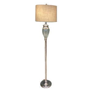 A floor lamp with a ribbed clear glass shade and a chrome metal finish. The lamp is turned on, showing the light reflecting off the shade.