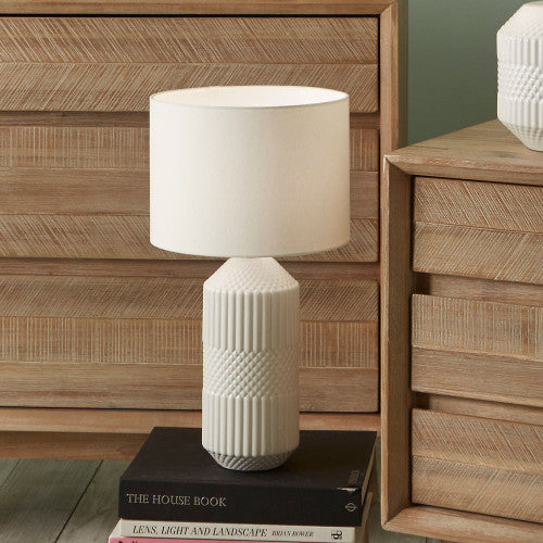 This beautiful tall ceramic table lamp features a textured tactile detail. Finished in a simple white glaze this lamp also comes complete with a matching white shade to finish the clean neutral look.